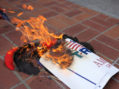 Anti-Trump demonstrators burn Trump's campaign items outside a campaign event for Republican U.S. presidential candidate Donald Trump in San Diego